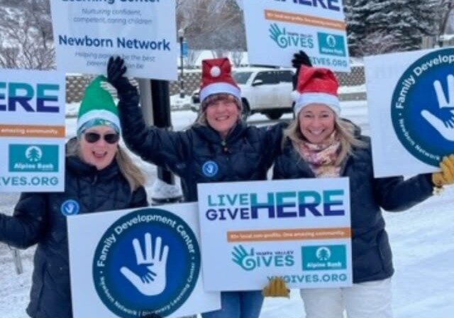 Photo of Family Development Center staff holding signs on Lincoln Ave. in Steamboat Springs, CO for Yampa Valley Gives Day 2024 Honk n Wave event.