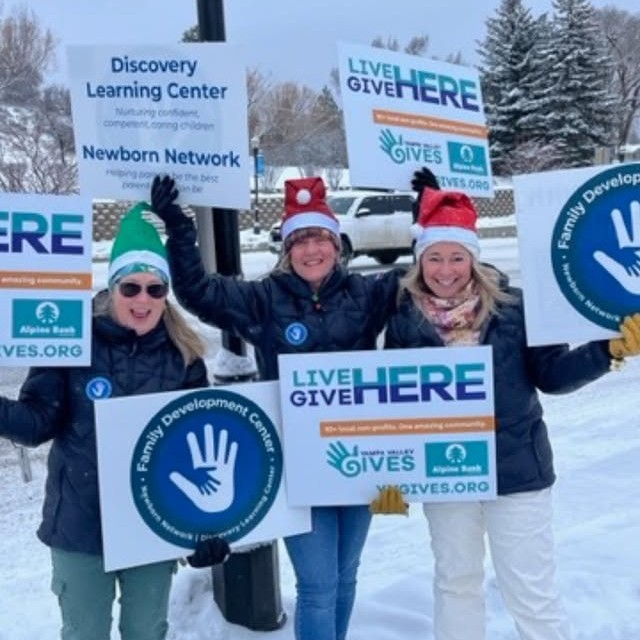Photo of Family Development Center staff holding signs on Lincoln Ave. in Steamboat Springs, CO for Yampa Valley Gives Day 2024 Honk n Wave event.